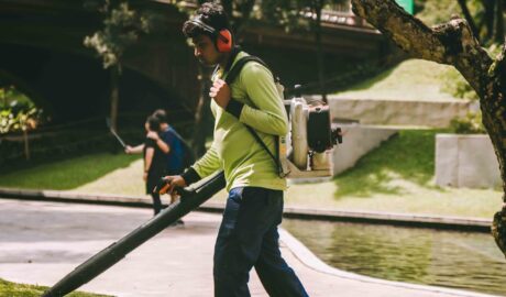 a man using a leaf blower in a park